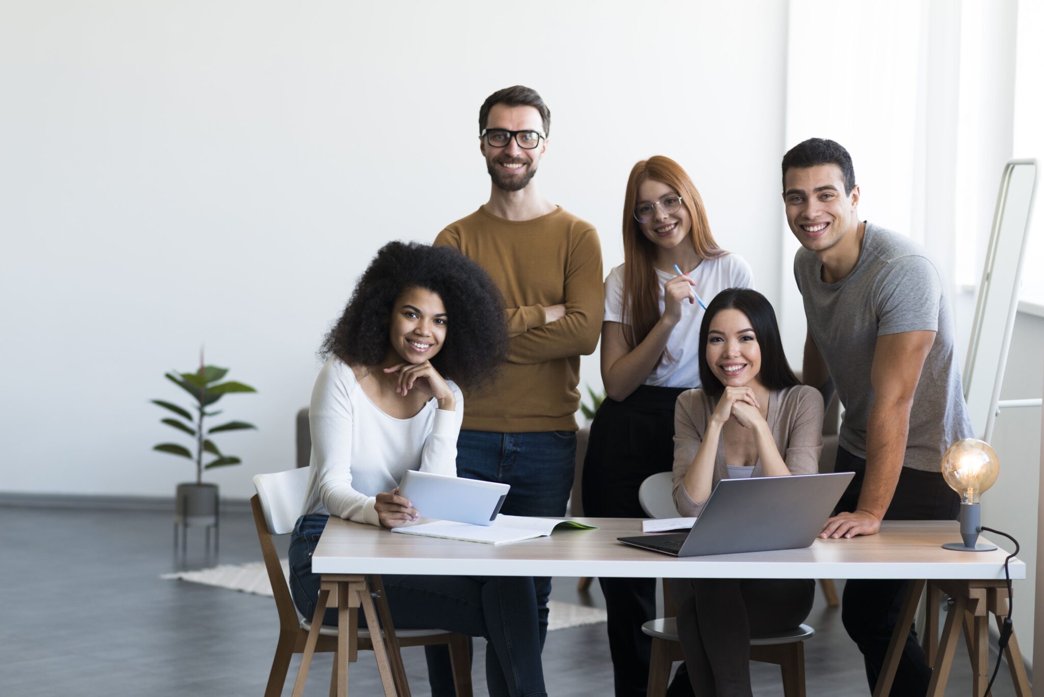 Deux hommes et trois filles regardent la caméra en souriant